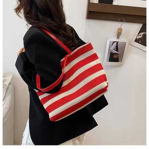 Dettaglio della borsa tote in maglia a righe rosse e bianche con tracolla per l'estate