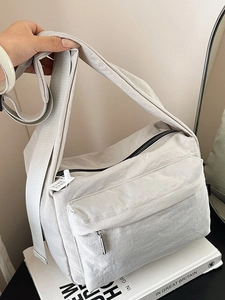 Minimalist light gray nylon crossbody bag with wide strap for casual daily use