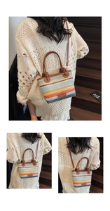 Detail of colorful striped woven straw bucket bag with leather handles and brand label