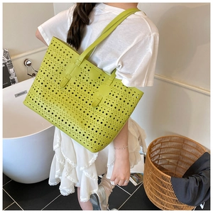 Detailed laser-cut dot texture on a bright green oversized tote bag shown on a model