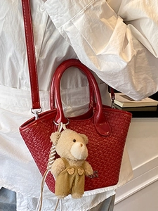 Borsa a secchiello rossa minimalista con trama intrecciata, manici tondi e ciondolo orso