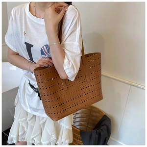 Detail of brown hollowed-out tote bag featuring intricate laser-cut patterns and large capacity