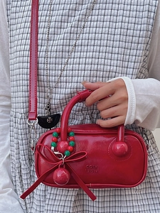 Fashionable red patent leather pillow bag with large bow and removable shoulder strap