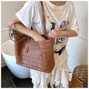 Detail view of brown laser-cut tote bag with hollow geometric patterns and open structure