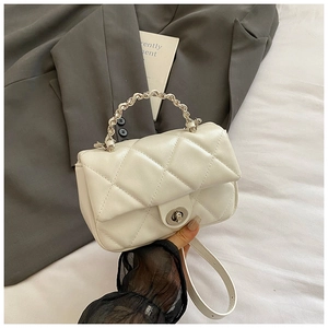 Detailed close-up of white quilted leather mini bag with silver chain handle and swivel lock