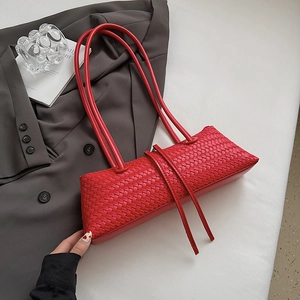 Detail shot of the red woven leather texture and elegant long straps on the shoulder bag