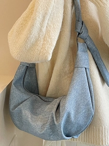 Blue denim minimalist hobo bag with knotted strap and half-moon pleated design