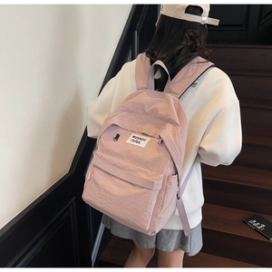Detail of light pink backpack made of crinkle texture fabric with wide shoulder straps