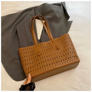 Detail of laser-cut geometric hollow pattern on brown large capacity tote bag