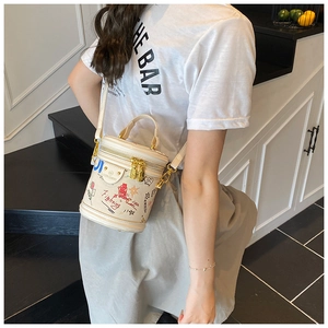 Detail of off-white bucket bag with playful graffiti prints and gold double zippers