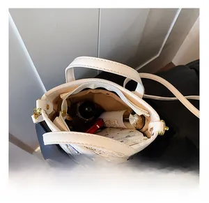 Top view showing the spacious interior of the white bucket bag with compartments