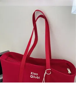 Gros plan sur la fermeture éclair et la texture du tissu en nylon rouge d'un grand sac