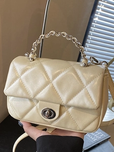Cream quilted mini shoulder bag with metallic chain handle and silver twist lock detail