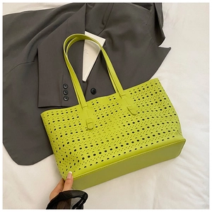 Detailed close-up of lime green laser-cut tote bag with hollow geometric patterns