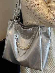 Metallic silver tote bag with dual chain straps and pearl charms for a modern fashion look