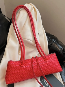 Red woven shoulder bag with intricate texture on a professional minimalist background