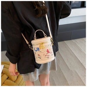 Detail view of cream-white bucket bag with colorful graffiti art and gold metal zippers