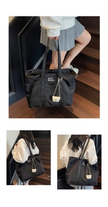 Détail d'un grand sac cabas noir en nylon avec petit porte-monnaie crème et bandoulières