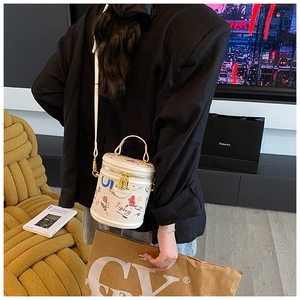 Detail view of white bucket bag with colorful graffiti and adjustable shoulder strap