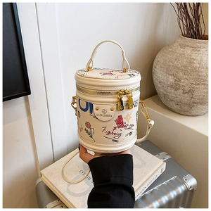 Detailed close-up of cream bucket bag with colorful cartoon graffiti and gold hardware