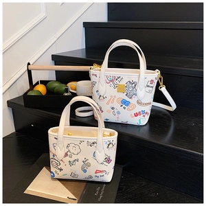 Detail of white graffiti tote bags with colorful heart prints on modern black stairs