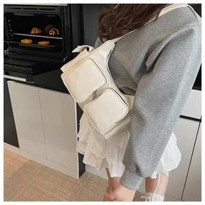 Chic cream multi-pocket shoulder bag with glossy finish shown in a cozy kitchen setting