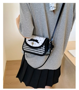Detail shot of heart pattern crossbody bag with checkered print worn by model