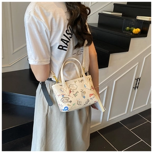 Detailed side view of a white mini graffiti bucket bag with gold hardware and shoulder strap