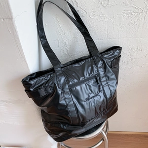 Detail of high-gloss waterproof nylon gym tote with zipper pocket and embroidery