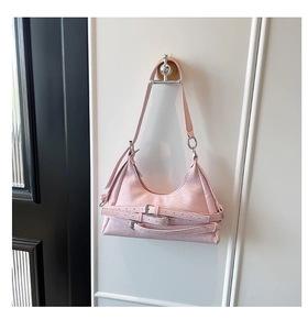 Détail du sac croissant rose clair en cuir grainé avec boucles métalliques décoratives