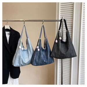 Detailed display of denim tote bags in light blue, dark blue, and black with tulip charms