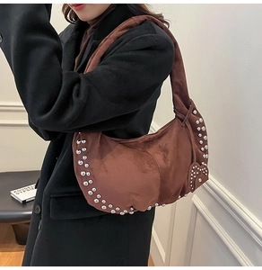 Vue détaillée du sac hobo en daim marron avec rivets argentés et décoration de cœur