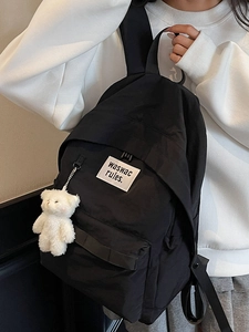 Chic black minimalist nylon backpack with white bear pendant and aesthetic letter patch