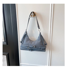 Détail du sac hobo gris avec sangles à boucles parallèles et garnitures métalliques argentées