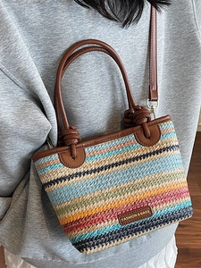 Rainbow woven straw bucket bag with brown leather handles and adjustable shoulder strap