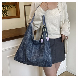 Detail of blue denim tote bag with white polka dots and purple tulip floral charms