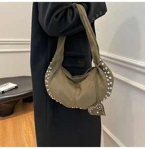 Vue détaillée du sac hobo en daim olive avec rivets argentés et pendentif cœur