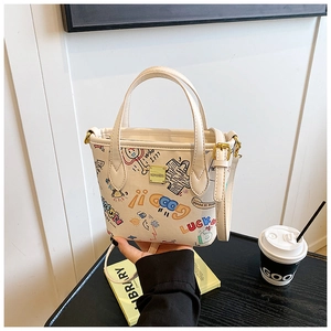 Close-up of cute cartoon graffiti bucket bag with gold logo and adjustable strap