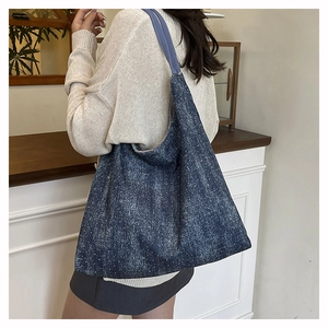 Detail of blue denim tote bag featuring sparkling rhinestone starry effects and wide strap