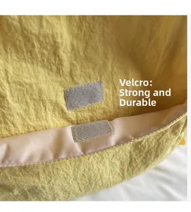 Detail of sturdy yellow canvas backpack featuring secure velcro closure and durable stitching