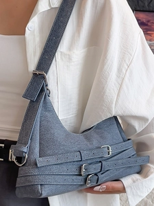 Sac croissant en denim bleu avec triple boucles argentées pour un style urbain chic