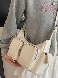 Fashionable cream glossy patent leather shoulder bag with multiple front zipper pockets