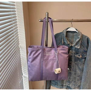Détail du sac cabas en toile violet avec poche frontale et logo blanc Xiao Qilubi