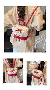 Close-up of white lace trim and red bow detail on a sweet style mini bucket backpack