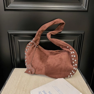 Détails du sac hobo en daim marron avec rivets argentés et accents métalliques en cœur