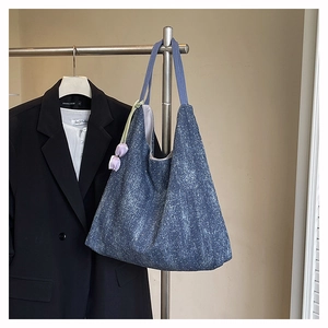 Detail of blue denim tote bag with floral texture and purple tulip pendant