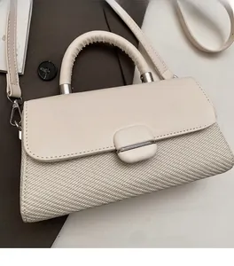 Detailed close-up showing dual-material texture stitching on the beige crossbody bag