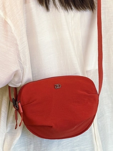 Minimalist red nylon crossbody bag with dual D logo and adjustable shoulder strap
