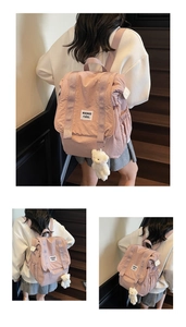Detail of light pink canvas backpack featuring a plush bear charm and brand patch