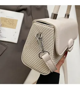 Close-up of beige leather and woven fabric stitching with silver metal buckle detail